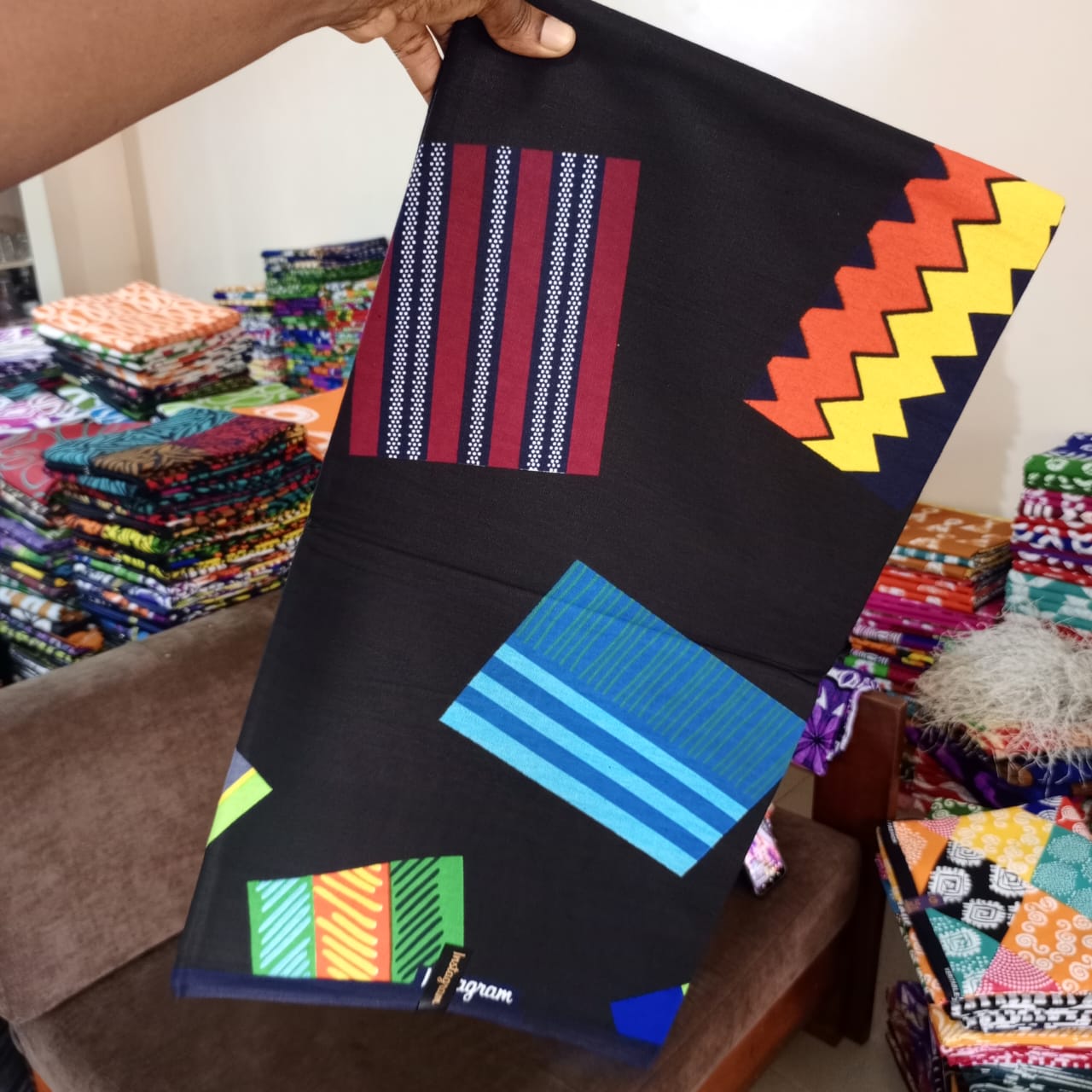 INTAGRAM FASHION WAX 100% COTON WAX NIGERIAN avec un fond noir avec patch géométrique multicolore bordeaux, bleu, jaune, orange, vert à motif rayé et zigzag