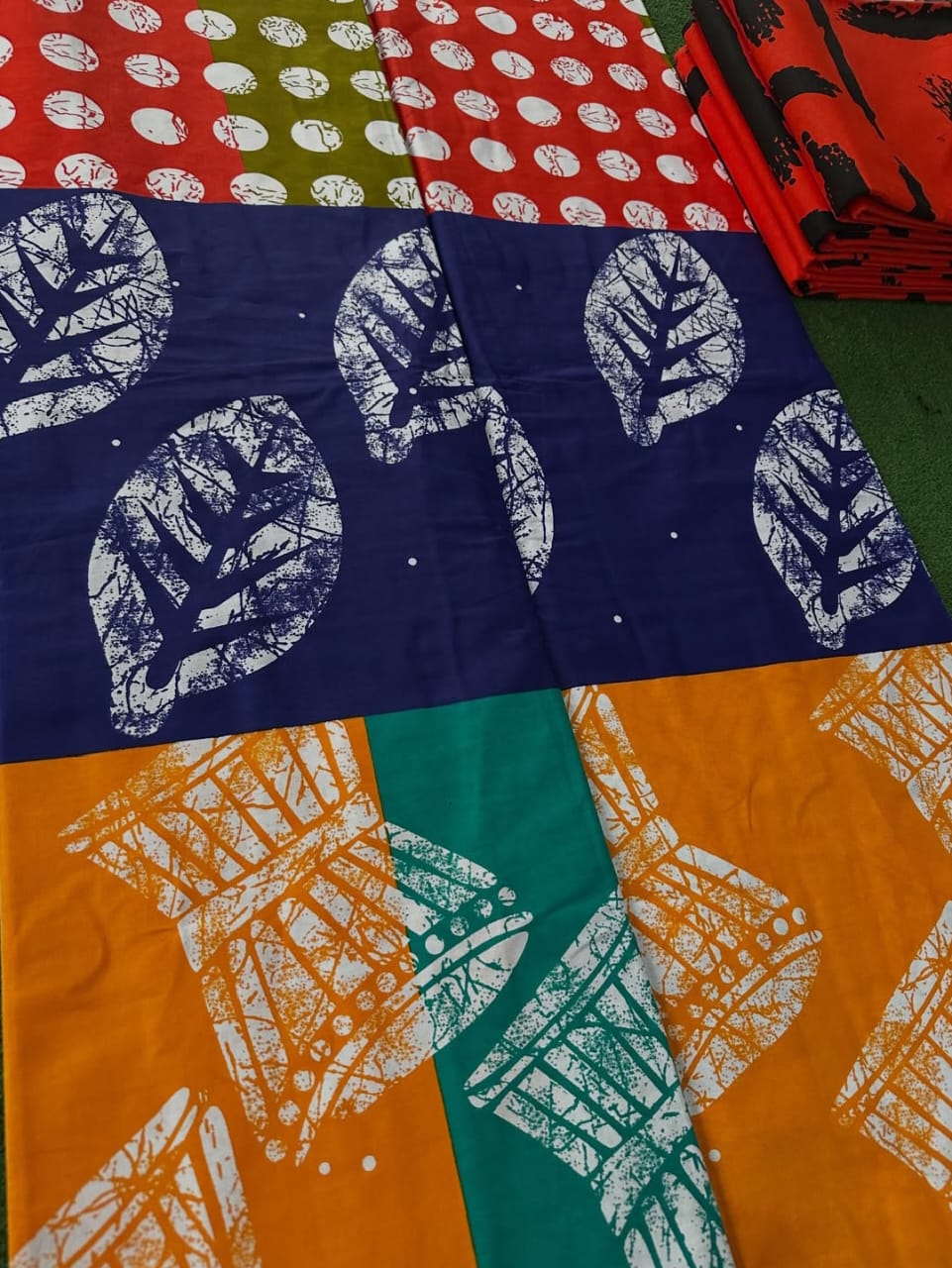 KANDY KRUSH 100% COTON WAX  NIGERIAN batik mixte tambours feuilles pois de couleurs bleu nuit, orange et rouge  